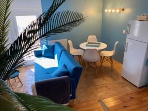 uma sala de estar com um sofá azul e uma mesa em Le Clos Bellevue em Tressan