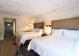 2 łóżka w pokoju hotelowym z białą pościelą w obiekcie Holiday Inn Fredericksburg - Conference Center, an IHG Hotel w mieście Fredericksburg