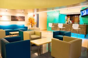 poczekalnia z niebieskimi krzesłami i barem w obiekcie Los Mirtos suite & Hotel w mieście Lima