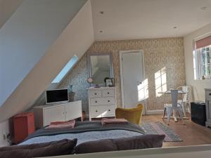 um quarto com uma cama, uma cómoda e um espelho em The Suffolk Cartlodge 
