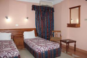 a hotel room with two beds and a mirror at Sea Star in Alexandria