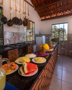 a kitchen with plates of fruit on a counter at Pousada Rosa Mistica in São Thomé das Letras