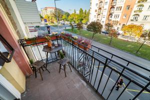 Un balcón con una mesa y sillas y una calle. en Cozy apartment in Budapest near Gellért Hill, en Budapest
