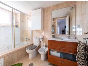 łazienka z toaletą, umywalką i lustrem w obiekcie Luxury Sunny Villa w Maladze
