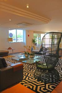 a living room with a chair on a rug at Condominio Barretos Thermas Park - Condohotel in Barretos +21 photos