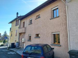 un pequeño coche aparcado frente a un edificio en Location A.M.I, en Bellegarde-sur-Valserine