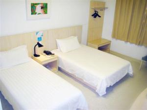a hotel room with two beds and a telephone at Jinjiang Inn - Suzhou Executive Center Hotel in Suzhou