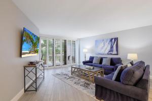 Una sala de estar con dos sofás y una mesa. en Beachfront condo with heated pool, gym and pickleball, en Marco Island