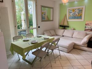 ein Wohnzimmer mit Sofa und einem Tisch mit Stühlen in der Unterkunft MedusaBlu121 in Punta Marina