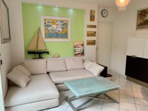 ein Wohnzimmer mit einem weißen Sofa und einem Tisch in der Unterkunft MedusaBlu121 in Punta Marina