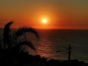 a sunset over the ocean with the sun in the sky at Pra la Vue in Durban