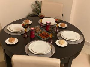 a black table with plates and wine glasses and food at Apartamento con piscina Torremolinos in Torremolinos +65 photos
