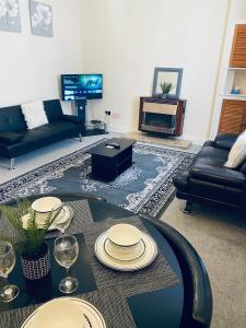 a living room with a table and a couch at Largs Holiday Apartment in Largs