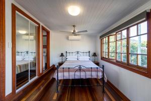 Island Adventure Holiday House في Picnic Bay: غرفة نوم مع سرير في غرفة مع نوافذ