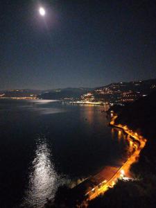 a view of a beach at night with a full moon at B&B del Centro in Capo dʼOrlando