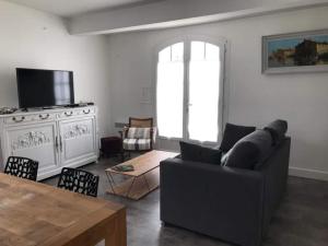 a living room with a couch and a table at St Mart. l'îlot Rhéa in Saint-Martin-de-Ré