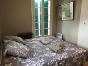 1 dormitorio con cama con almohadas y ventana en St Mart. l'îlot Rhéa, en Saint-Martin-de-Ré