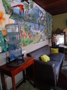 a living room with a couch and a large mural at Managua Backpackers Inn in Managua