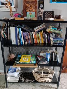 a book shelf filled with books and a basket at Managua Backpackers Inn in Managua