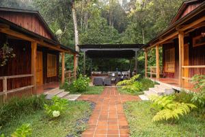 un patio avec une passerelle en briques entre deux bâtiments dans l'établissement Estancia del Monje, à Cobán