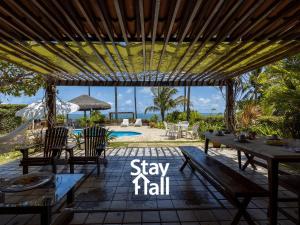 a patio with a table and chairs and the words stay tall at Casa Beira Mar-Cozinheira-Piscina Privad-4QT-SH029 in Sirinhaém