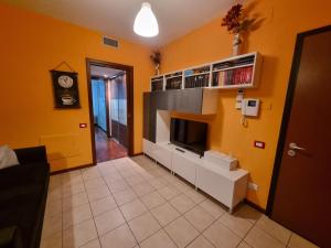 a living room with yellow walls and a clock at AMA Milano Intero appartamento Bicocca Zona 9 in Milan