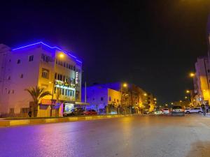 Una calle de la ciudad por la noche con edificios y luces. en HOTEL NOON, en Laayoune 24 fotos más