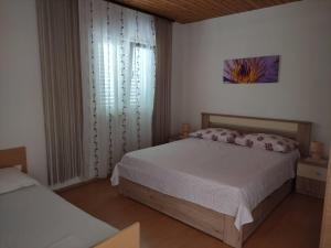 een slaapkamer met 2 bedden en een raam bij Apartments Anđelka - 50 m from beach in Marina