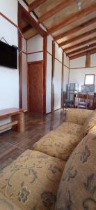 a living room with a couch and a flat screen tv at Cabañas leumo in Manzanar