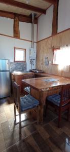 a kitchen with a large wooden table and chairs at Cabañas leumo in Manzanar