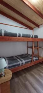 two bunk beds in a room with a table at Cabañas leumo in Manzanar