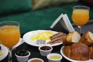 - une table avec des aliments pour le petit-déjeuner et 2 verres de jus d'orange dans l'établissement HOTEL NOON, à Laâyoune