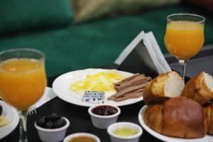 uma mesa com comida para o pequeno-almoço e dois copos de sumo de laranja em HOTEL NOON em Laayoune