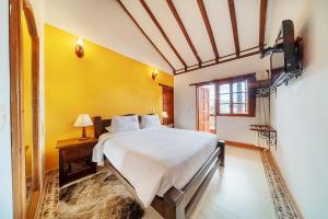 Säng eller sängar i ett rum på Hotel Jardines De La Villa