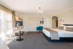 a hotel room with two beds and a television at Silver Fern Rotorua Suites & Spa in Rotorua