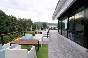 a balcony with white chairs and tables on a building at Boutique Huahin Pool Villa in Hua Hin