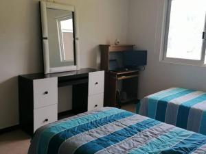 um quarto com uma cómoda, um espelho e uma cama em Departamento en condominio Diamante Turquesa em Acapulco