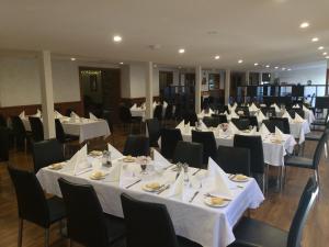 une salle de banquet avec des tables blanches et des chaises noires dans l'établissement Bright Chalet, à Bright