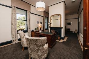 a room with a desk and chairs and a mirror at Hotel Etico at Mount Victoria Manor in Mount Victoria