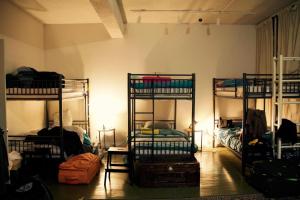 a room with three bunk beds in it at The Parkdale Hostellerie in Toronto