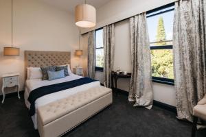 a bedroom with a bed and a large window at Hotel Etico at Mount Victoria Manor in Mount Victoria