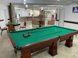 a pool table in a room with chairs and tables at Pampas Palace Hotel in São Bernardo do Campo