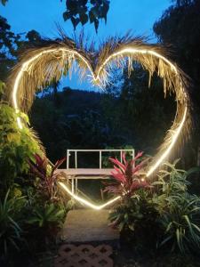 un panneau en forme de cœur avec des lumières dans un jardin dans l'établissement Hilltop Canopy Staycation, à Kinalaglagan