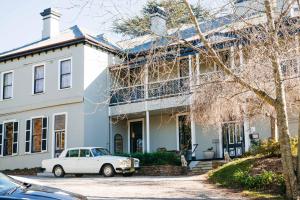 a white car parked in front of a white house at Hotel Etico at Mount Victoria Manor in Mount Victoria