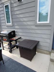 een grill en een picknicktafel naast een huis bij SPACIOUS TOWNHOUSE MINUTES FROM DOWNTOWN SA. in San Antonio