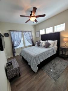 - une chambre avec un lit et un ventilateur de plafond dans l'établissement SPACIOUS TOWNHOUSE MINUTES FROM DOWNTOWN SA., à San Antonio