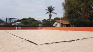 un court de tennis avec un filet dans le sable dans l'établissement Pousada Vila Minas, à Itanhandu