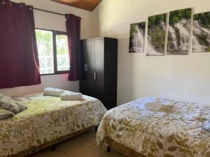 1 dormitorio con 2 camas, armario y ventana en Cabañas Mountain View en Volcán