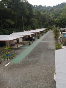 una larga fila de edificios con un coche aparcado delante en Puerto Vargas lodge, en Cahuita