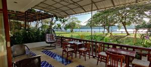 Krabi River Hotel في مينْغكرابي: مطعم به طاولات وكراسي ومطل على المحيط